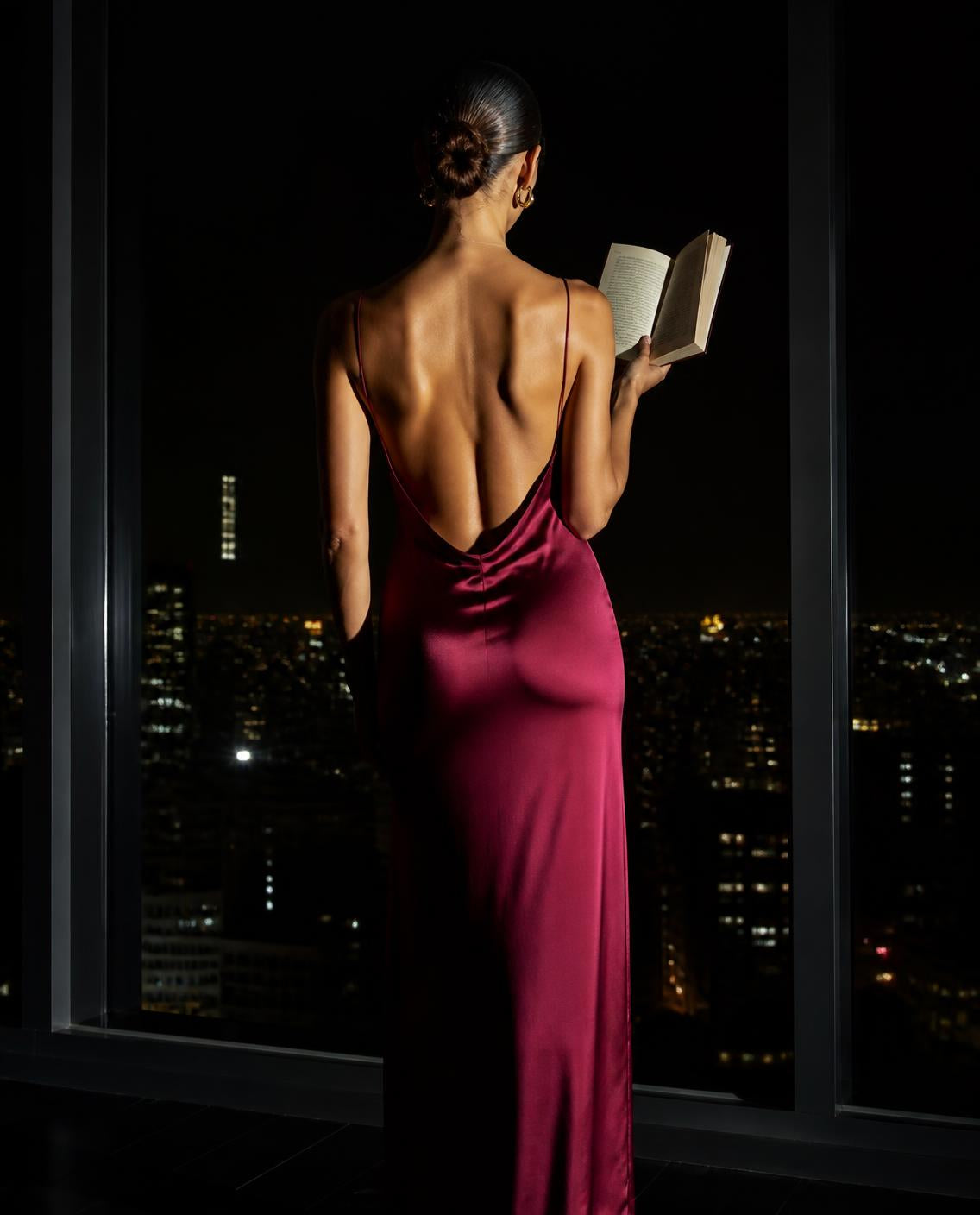 A hand in a satin glove holding a note over an open book